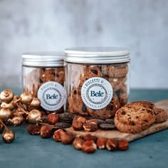 two jars filled with cookies and nuts on top of a table