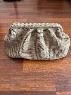 a knitted purse sitting on top of a wooden floor next to a pair of shoes