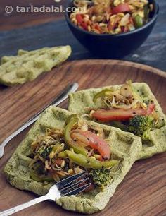 two waffles topped with vegetables on a wooden plate