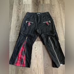 These Skater Pants Will Make A Statement Wherever You Go . Black Pants With Razor Blade Style Zippers . When Bottom Zipper Is Opened , It Has A Red Plaid Print Inside Turning Them Into A Flare Pant . Alternative Style Black Pants With Zip Fly, Punk Style Black Bottoms With Zip Fly, Fitted Cotton Bottoms With Side Zipper, Edgy Cotton Bottoms With Zip Fly, Edgy Red Straight Leg Bottoms, Edgy Wide Leg Bottoms With Zipper Closure, Edgy Red Bottoms With Pockets, Black Punk Bottoms With Zip Fly, Alternative Style Black Pants With Zipper Closure