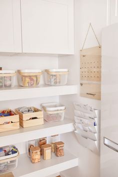 the shelves in this kitchen are organized with plastic containers and bins for food storage