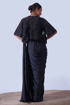 Black flared sleeves cut work cape with all over helix garden embroidery using tonal crystals, beads embroidery and dangling bead tassels on the hem. Paired with a padded draped V neck blouse and a pre-draped saree with tonal crystal gardenia embellishments on the centre saree skirt panel. - Aza Fashions Festive Pre-draped Evening Blouse Piece, Fitted Pre-draped Blouse Piece For Evening, Evening Pre-draped Saree With Sequins And Cape Sleeves, Evening Embellished Draped Blouse Piece, Embellished Draped Evening Blouse Piece, Fitted Pre-draped Saree For Evening, Festive Evening Blouse With Draped Sleeves, Fitted Draped Evening Saree, Fitted Evening Saree