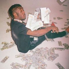 a man laying on the floor with lots of money in front of him and looking up