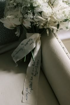 a bouquet of white flowers sitting on top of a table next to a roll of paper