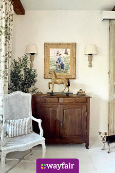 a living room with two chairs and a painting hanging on the wall above it's door