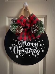 a merry christmas door hanger with pine cones and evergreens on it's side