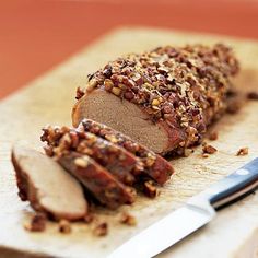 a sliced meatloaf on a cutting board next to a knife