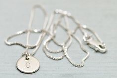 Sterling silver initial necklace - This minimalist necklace features a petite but thick sterling silver disc, hand stamped with your chosen initial and suspended from lovely sterling silver box chain. Arrives gift boxed in Sea and Cake packaging.*Length on model is 16 inches. *All components are sterling silver.*Available with 1-3 discs.*Sterling silver disc is 9mm and 20 gauge thick.*Handmade with love in the USA!*Initial(s) will be in uppercase block font.For more Sea and Cake: Pinterest - htt Classic Sterling Silver Charm Necklaces With Initials, Classic Sterling Silver Initial Necklace For Personalized Gift, Classic Sterling Silver Initial Pendant Charm Necklace, Silver Minimalist Personalized Initial Necklace, Dainty Silver Name Necklace For Everyday, Minimalist Sterling Silver Initial Pendant Name Necklace, Simple Sterling Silver Initial Pendant Necklace, Classic Sterling Silver Initial Round Pendant Necklace, Silver Minimalist Initial Necklace With Delicate Chain