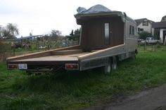 a truck with a trailer attached to it parked in the grass