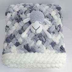 there is a stuffed sheep on top of a blanket