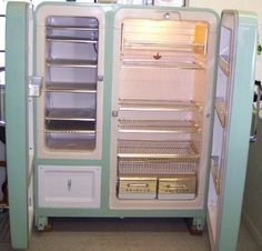 an old refrigerator with its doors open in a kitchen