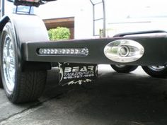 the front end of a white truck with chrome rims and an emblem on it