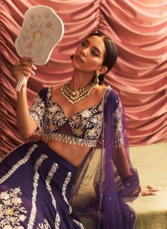 Make a grand entrance in this stunning purple embellished blouse, paired with a voluminous lehenga featuring cancan for added flair and drama. The matching dupatta completes the ensemble, creating a captivating look that is perfect for weddings and festive celebrations. Purple Sharara With Sheer Dupatta And Traditional Drape, Traditional Purple Sharara With Sheer Dupatta, Purple Sharara With Sheer Dupatta In Traditional Drape, Purple Sharara With Cutdana And Traditional Drape, Purple Anarkali Style Sharara With Cutdana, Purple Sharara For Navratri With Traditional Drape, Purple Sharara For Festivals With Traditional Drape, Purple Traditional Drape Sharara For Festivals, Purple Anarkali Set With Cutdana For Weddings