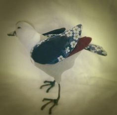 a white and blue bird with flowers on it's body