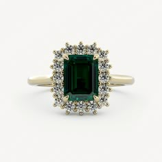 an emerald and diamond ring on a white background