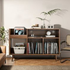 a living room with a couch, chair and bookshelf on the floor in front of a window