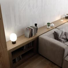 a living room with a couch, bookshelf and lamp on the side wall