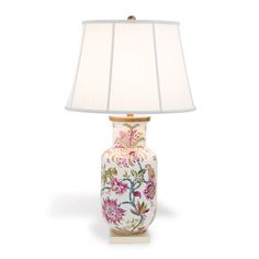 a lamp that is sitting on top of a white surface with a flowered design