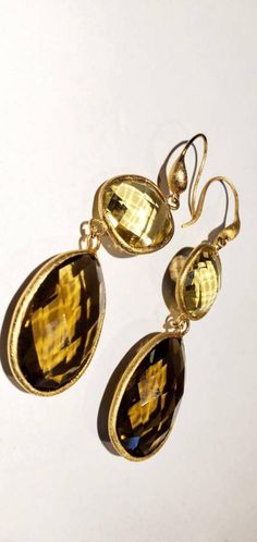 These vintage earrings are quite stunning and just what you need for special occasions. They feature faceted round and teardrop shaped smoky and yellow quartz in gold settings that catch the light just perfectly. They dangle from gold-toned ear wires. From the top of the wire to the bottom of the pearl, they measure 3 inches. These earrings are in very good vintage condition. Thanks for visiting my vintage jewelry store! Back to my shop here: https://www.etsy.com/shop/RemembrancesofYours Gold Teardrop Gemstone Earrings, Vintage Gold Teardrop Earrings For Party, Gold Faceted Drop Earrings, Gold Teardrop Earrings With Gemstone For Anniversary, Gold Faceted Earrings For Anniversary, Gold Gemstone Teardrop Earrings For Formal Occasions, Gold Faceted Citrine Earrings, Gold Citrine Faceted Earrings, Gold Drop Earrings With Faceted Details