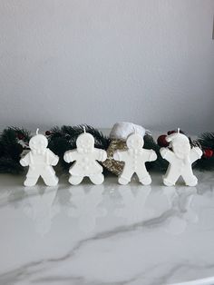 three white christmas decorations on a counter top