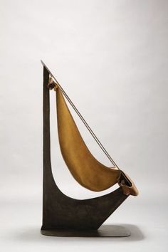 a sculpture made out of wood and metal with a sail on it's side