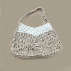 Enhance your everyday look with this elegant handmade crochet shoulder bag, featuring a soothing combination of beige and white. Expertly crafted from high-quality yarn, this bag boasts a soft texture and durable construction, perfect for daily use. With its generous dimensions (18 inches in width and 12 inches in length), this bag provides ample space for all your essentials. Features: Design: Classic two-tone in beige and white Material: Soft, durable yarn Size: 18 inches (width) x 12 inches (length) Straps: Comfortable crocheted shoulder strap Care: Hand wash recommended Whether you're heading to work, running errands, or enjoying a casual day out, this stylish shoulder bag is the perfect accessory. Its timeless design and practical functionality make it a must-have addition to any ward Beige Knitted Shoulder Bag For Everyday Use, White Crochet Bag For Everyday, White Crochet Bag For Everyday Use, Beige Knitted Straw Bag For Daily Use, White Rectangular Crochet Bag For Everyday, Beige Knitted Shoulder Bag For Daily Use, Casual Cream Crochet Bag For Everyday, White Straw Shoulder Bag For Everyday Use, White Crochet Tote Bag For Daily Use