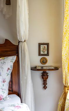 a bed room with a neatly made bed next to a wall mounted clock and window