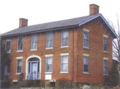 an old red brick house with white trim