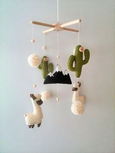 an animal mobile is hanging on the wall next to a cactus and cacti