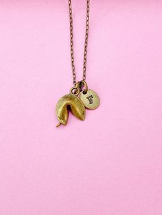 This is bronze-tone alloy fortune cookie charm with hand stamped initial charm on brass or stainless-steel chain. ♥ You will receive ONE necklace. HOW TO ORDER 1) Choose the quantity. 2) Choose the initial in the option or add a note to seller at checkout. 3) Add to the cart. DESCRIPTION ♥ Necklace, Brass Chain with Lobster Claw Clasp, Size: about 17.7 inches (45cm) long, 1-2mm wide, Nickel Safe,  ♥ Initial Charms, Brass or Stainless Steel, Size: about 8-10mm in diameter, 1mm thick, Nickel Safe, ♥ Cookie, Alloy Pendants, Golden, Size: about 20mmx 14mm long, 3-Dimensional  ♥ Materials are sourced both domestically and internationally, and the final products are made and shipped from Gowen, Michigan. GIFT READY: ♥ An invoice will not be included in the package unless specifically requested. Red Tigers Eye, Fortune Cookie, Jewelry Card, Oils For Skin, Initial Charm, Brass Chain, Steel Chain, Stainless Steel Chain, Charm Necklaces