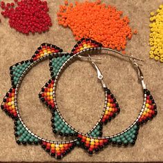 three pairs of beaded hoop earrings sitting next to each other on top of a table