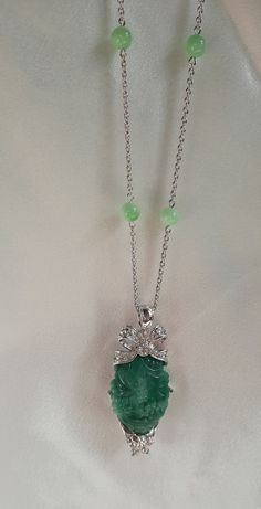 This lovely vintage signed Nolan Miller silver tone pendant necklace features Peking glass beads, sparkling clear Swarovski crystal rhinestones and a large carved faux jade centerpiece. The pendant and silver tone chain are marked Nolan Miller. The necklace is 36 in. L and the pendant is 2-7/8 in. L. This necklace is in very good vintage condition. Elegant Round Jade Crystal Necklaces, Elegant Jade Pendant Crystal Necklace, Silver Jeweled Crystal Necklace For Formal Occasions, Elegant Jade Necklace With Large Pendant, Elegant Silver Jeweled Crystal Necklace, Silver Jeweled Round Necklace, Silver Jeweled Round Necklaces, Elegant Jade Necklace With Stones, Elegant Pendant Crystal Necklaces With Rhinestones