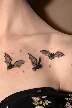 a woman's chest with bats and flowers on her left side, in black ink