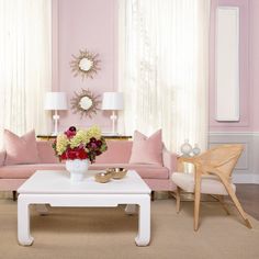 a living room filled with furniture and pink walls