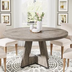 a round wooden table with four chairs around it in front of a white rug and pictures on the wall