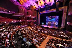 an auditorium filled with people sitting in chairs