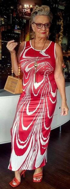 an older woman in a red and white dress posing for the camera with her hand on her hip