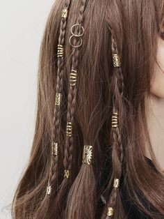 a woman with long brown hair has gold rings on her head