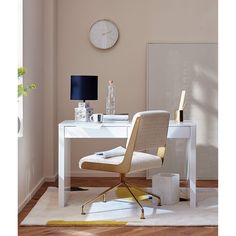 a white desk with a clock on the wall above it and a chair next to it