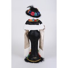 a black mannequin headdress with flowers and feathers