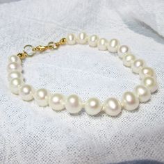 Gorgeous cultured real pearls hand knotted with silk thread, a classic look. These lustrous oval pearls are white and almost perfect.  Since pearls are a natural material, there may be slight variations. Pearls are a great Christmas gift for your wife, especially for your 3rd Anniversry. Pearls are one of June's birthstones, a great birthday gift.  Also pearls are classic looks for weddings and job interviews.  Perfect gifts for brides, bridesmaids and new college graduates on the job market.  Choose  a gold colored or silver colored lobster claw clasp.   7 inches is the average bracelet length.  Choose your custom fit from the drop down menu/message me if you don't see your preferred bracelet length in the drop down menu. I recommend 1 inch longer than your actual wrist size.  Measure you Real Pearl Bracelet, Gifts For Brides, 3rd Wedding Anniversary, Best Friend Birthday Gift, Friend Birthday Gift, Christmas Gifts For Wife, Wedding Jewelry Bracelets, Gift For Brother, Best Friend Birthday