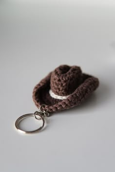 a crocheted keychain with a small hat on it's side