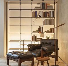 a living room filled with furniture and bookshelves next to a wall mounted book shelf