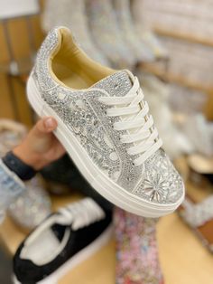 Put a little sparkle in your step with the REILY rhinestone sneakers. This sneaker can be paired with your best dress or favorite jean! Its intricate pattern is an eye-catching way to make a statement, no matter where you're wearing it. Manmade rhinestone platform sneakers Lace up closure Textile lining Rubber sole 1.5 inch platform Imported Luxury Party Sneakers With Glitter Accents, Spring High-top Sneakers With Rhinestones, Spring Bling Sneakers With Round Toe, Embellished Low-top Sneakers For Spring, Trendy Sparkling Low-top Sneakers, Casual Rhinestone Sneakers For Spring, Casual Bling Lace-up Sneakers, Embellished Lace-up Sneakers For Streetwear, Casual Bedazzled Sneakers