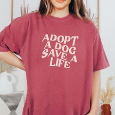 a woman wearing a red shirt that says adopt a dog save a life