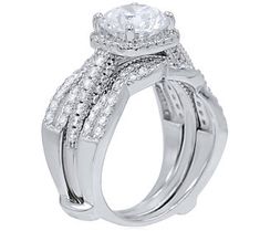 a white gold ring with two rows of diamonds on the band and an oval shaped center stone