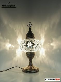 an ornate lamp with a crystal star on it's top is shown in front of a gray background