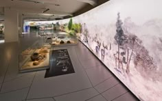 a large wall with paintings on it in a museum like setting that is well lit