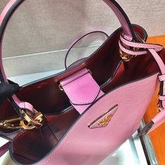 a pink and black purse sitting on top of a table