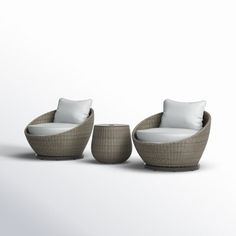 three wicker chairs and two stools with white pillows on the back, all facing each other